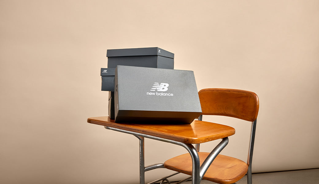 New Balance Schuhkartons auf Schulbank